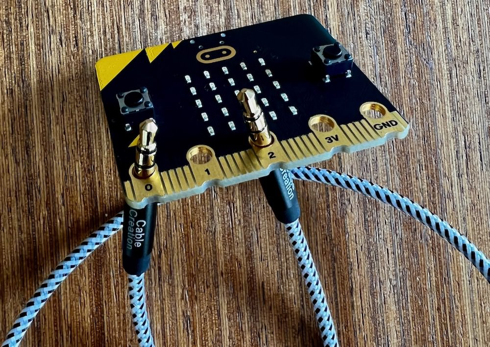 A microbit with ring 0 and ring 2 connected by an audio cable